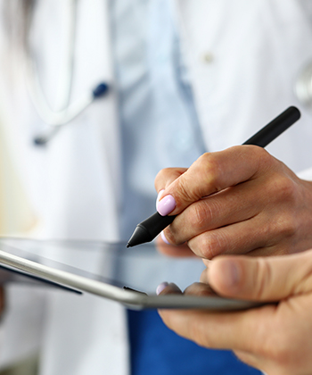 close up of hands typing on a tablet signing
