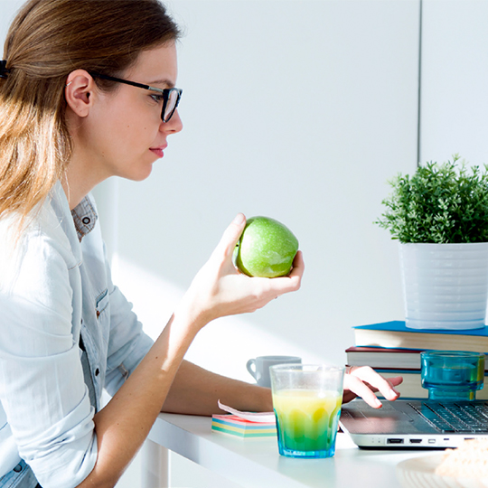 women holding apple and looking at screen