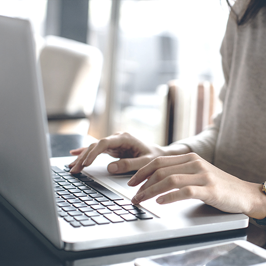 women typing on laptop