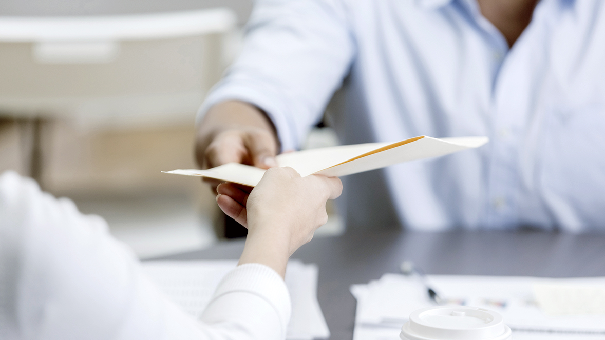 two people passing papers