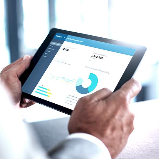 Take advantage of what automation can offer close up of hands holding a tablet showing a graph