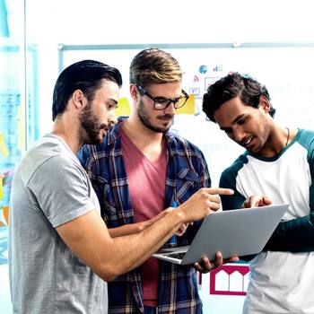 Collaboration is key to success office workers looking at a laptop