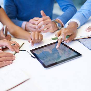 Whitepapers close up of people around a tablet