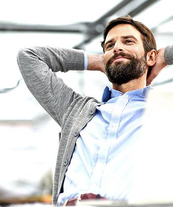 Printing solutions to make a business run smoothly man reclining in his chair with hands behind his head