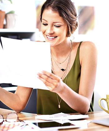 Powerful, reliable and economical woman smiling while reading a document