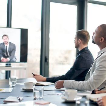 people in a room looking at a screen
