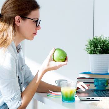 women holding apple and looking at screen